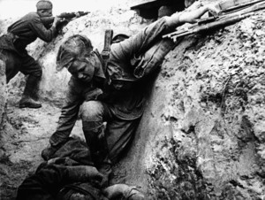 Советская санитарка оказывает помощь раненому красноармейцу под вражеским огнем